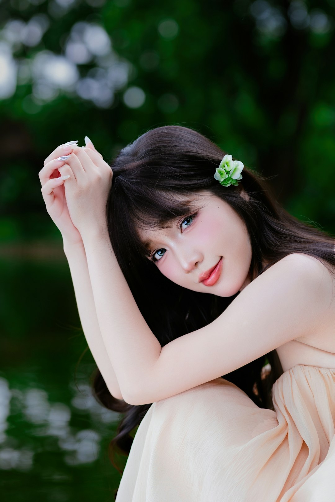 Young woman with flower in hair by water