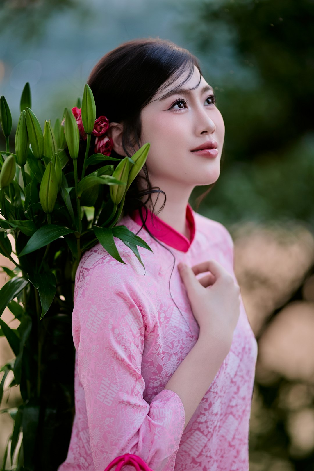 Young woman in pink dress holding lilies