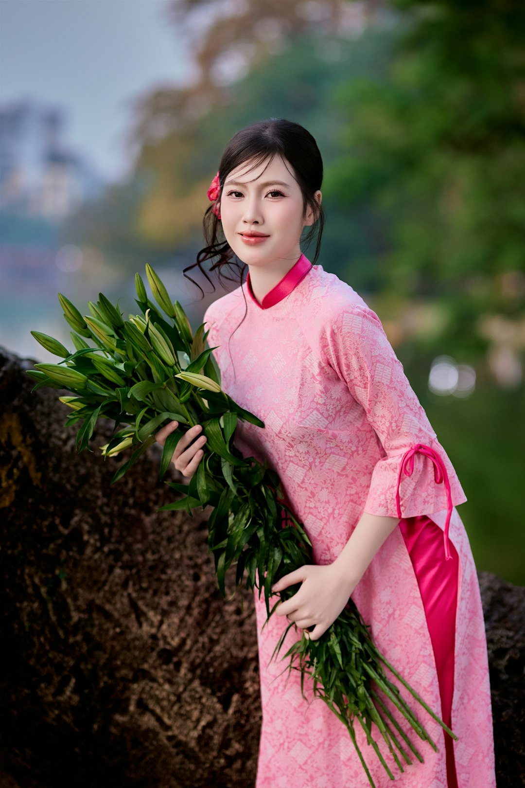 Young woman in pink dress holding green leaves