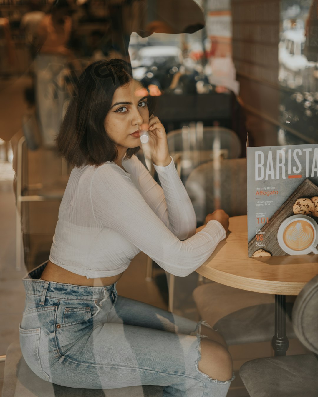 a woman sitting at a table talking on a cell phone